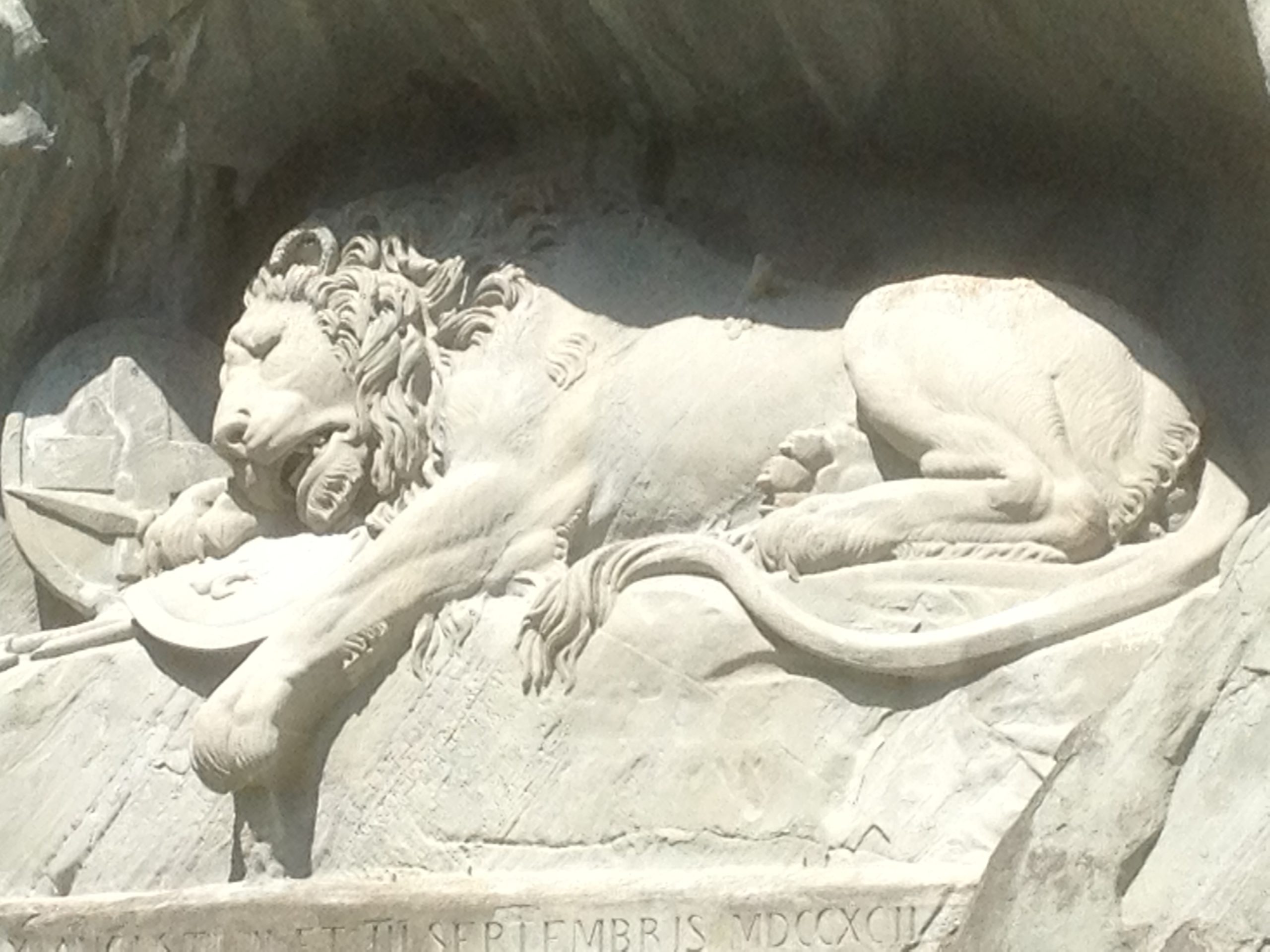 Lion monument carved in stone wall.