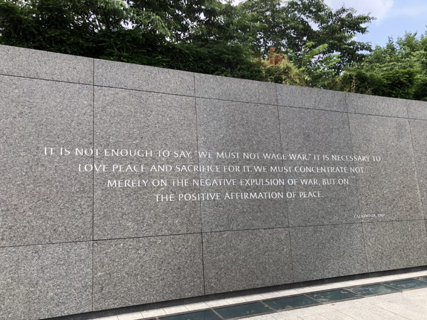Stone wall with peace-related quote engraved.
