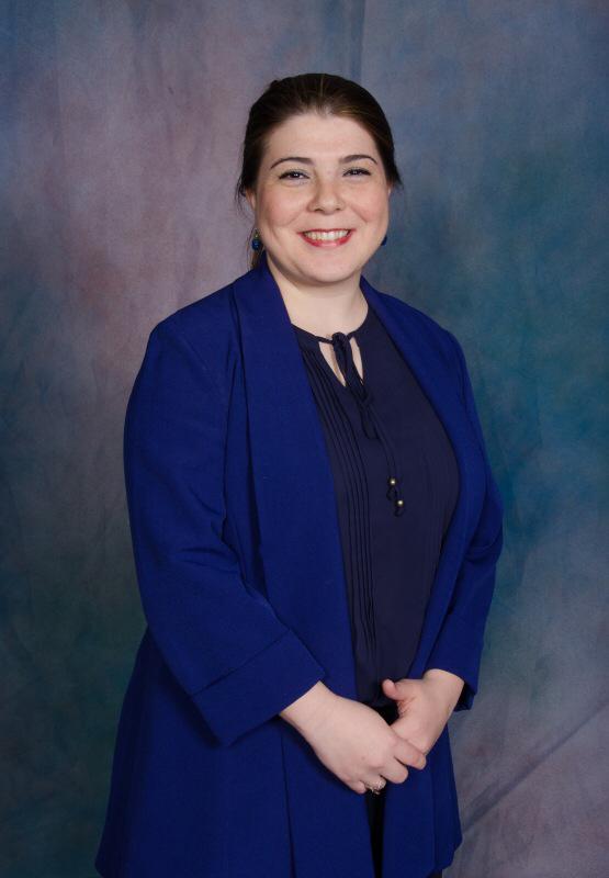 Smiling woman in blue professional attire.